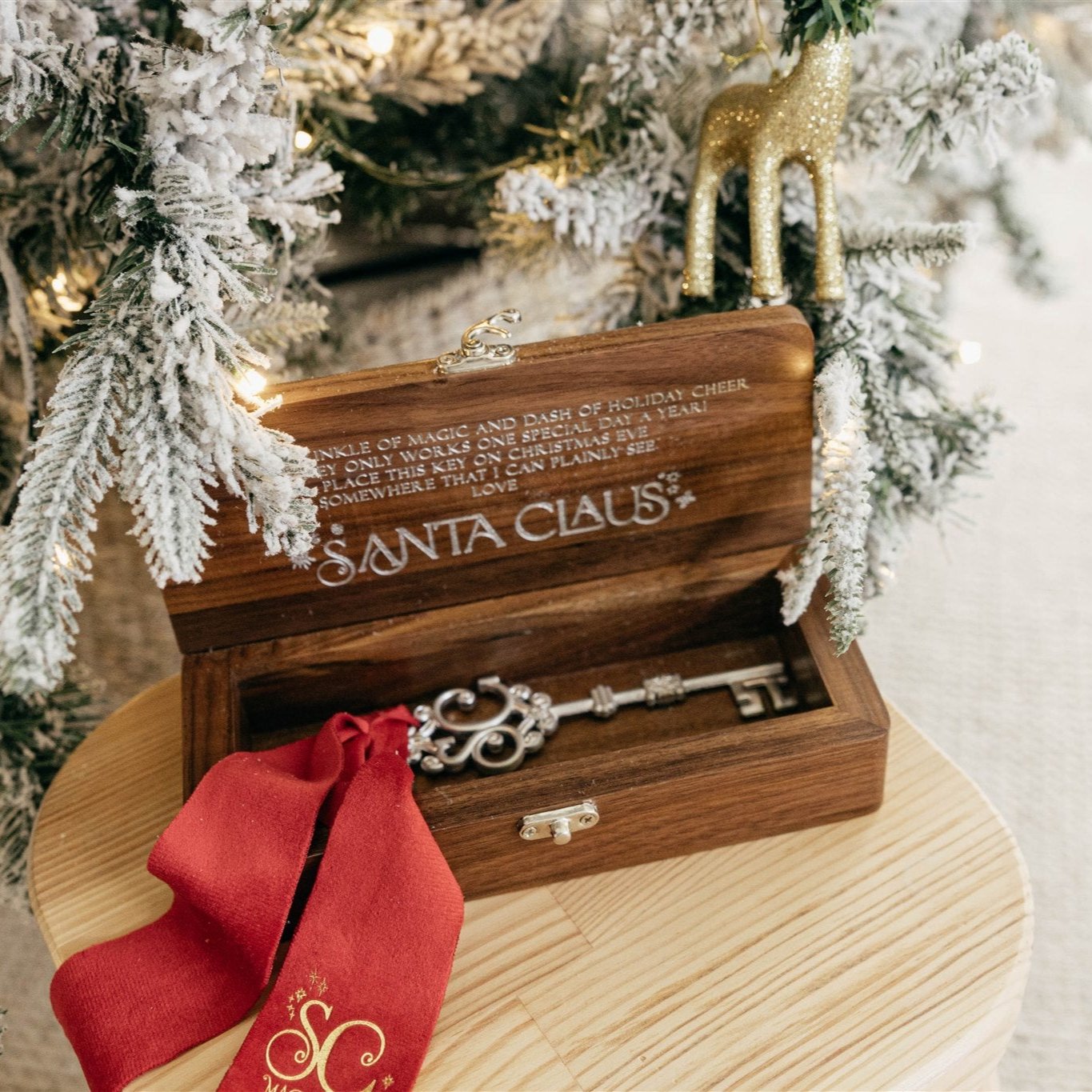 A wooden keepsake box with Santa Claus written on it, containing a decorative silver key