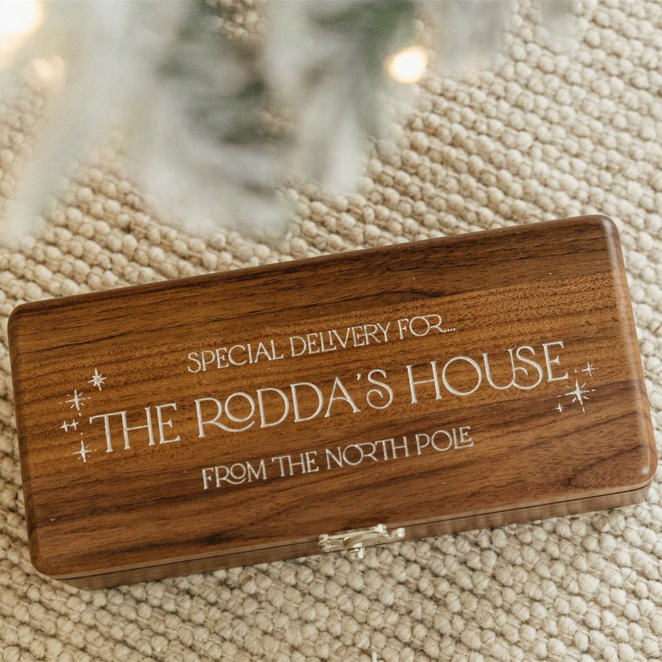 A wooden keepsake box with Santa Claus written on it, containing a decorative silver key